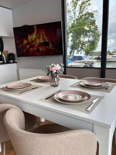 a dining room table with plates and flowers on it at Houseboat -La Calma- Czaplinek in Czaplinek