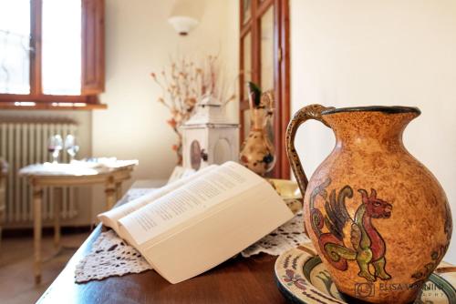 a vase sitting on a table with a book at Il Glicine in Palaia