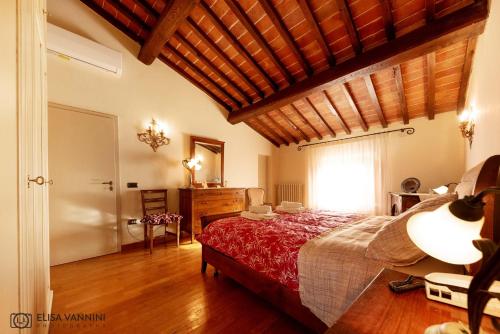 a bedroom with a large bed with a wooden ceiling at Il Glicine in Palaia
