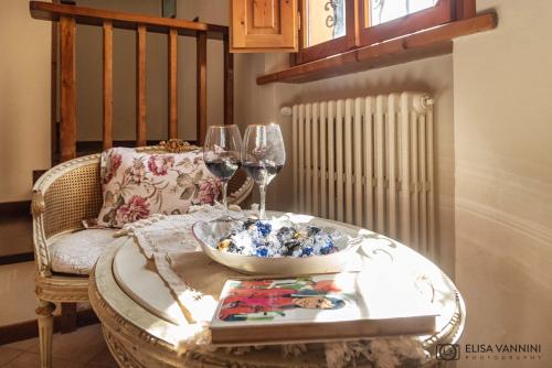 a table with two wine glasses and a bowl on it at Il Glicine in Palaia