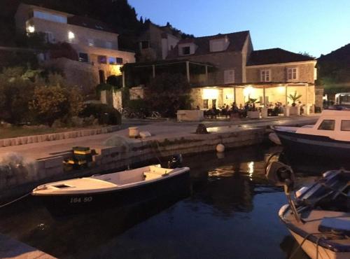 a couple of boats docked in the water at night at Mali Skoj Apartment in Suđurađ