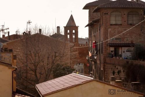 an old building with a clock tower in a city at Il Glicine in Palaia