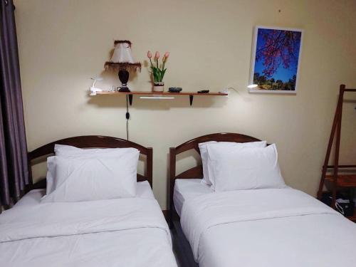 two beds sitting next to each other in a room at Stay&Stitch in Chiang Rai