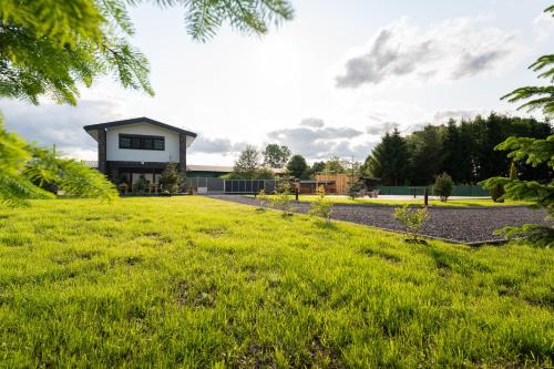 a house with a green lawn in front of it at Chaty Svätý Kríž in Svätý Kríž