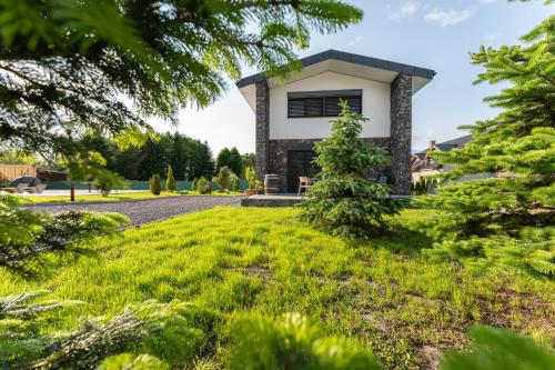 a house with a green lawn in front of it at Chaty Svätý Kríž in Svätý Kríž