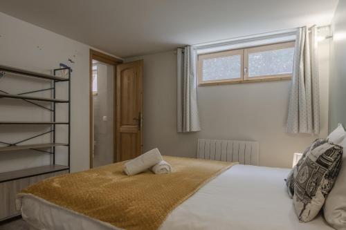 une chambre avec un grand lit et une fenêtre dans l'établissement Pierre Belle - 80m2 - Grande Terrasse et Jardin, à Chamonix-Mont-Blanc