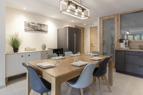une cuisine et une salle à manger avec une table et des chaises en bois dans l'établissement Pierre Belle - 80m2 - Grande Terrasse et Jardin, à Chamonix-Mont-Blanc