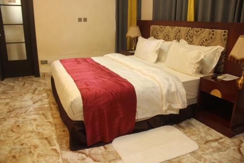 a bedroom with a large bed with a red blanket on it at Hunters Royal Hotel in Trofwi