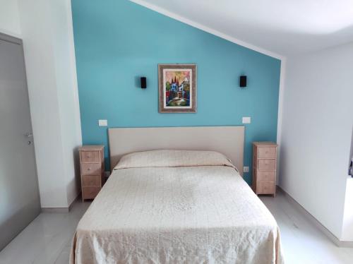 a bedroom with a bed with a blue wall at Affittacamere Ristorante Lo Scudo in Vasto