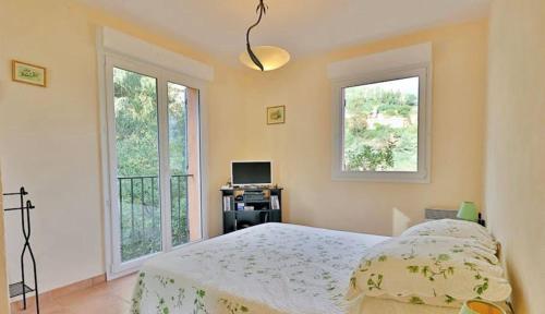 une chambre avec un lit et deux fenêtres dans l'établissement La Parenthèse Provençale, à Théoule-sur-Mer