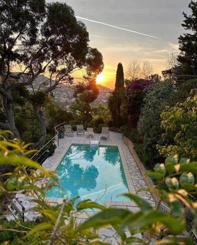 - une piscine avec des chaises et un coucher de soleil en arrière-plan dans l'établissement La Parenthèse Provençale, à Théoule-sur-Mer