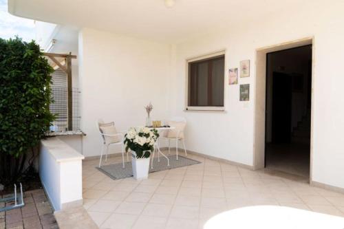 a patio with a table and chairs in a building at Villa Vitalis - 400 mt dalle spiagge in Torre Santa Sabina