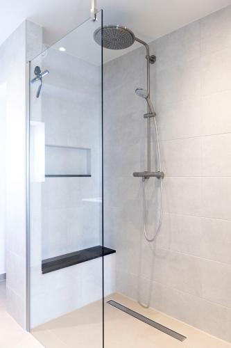 a shower with a glass door in a bathroom at Appartement Spoorklokken in Bergen aan Zee