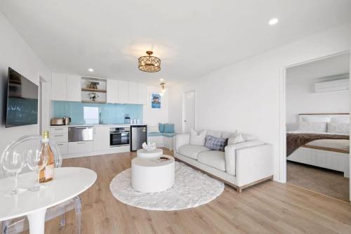 a living room with a couch and a table at Wanaka Studio - sea views from your private patio in New Plymouth