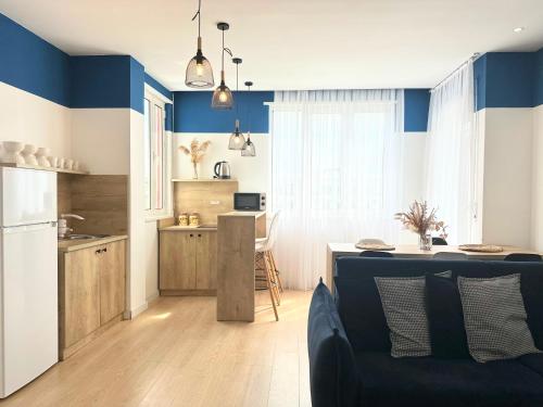 a kitchen and living room with blue walls and a couch at PROMO Elegant Apartments NEW - Colorful by the sea in Durrës