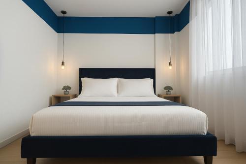 a bedroom with a large bed with a blue headboard at PROMO Elegant Apartments NEW - Colorful by the sea in Durrës