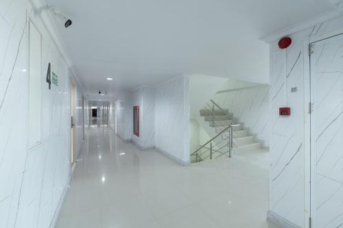 a white hallway with a staircase in a building at TJ 4711 Residence in Maha Sarakham