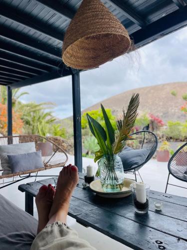 a person with their feet on a wooden table at Finca Malvasia Rural Estate & Vineyard in Tías