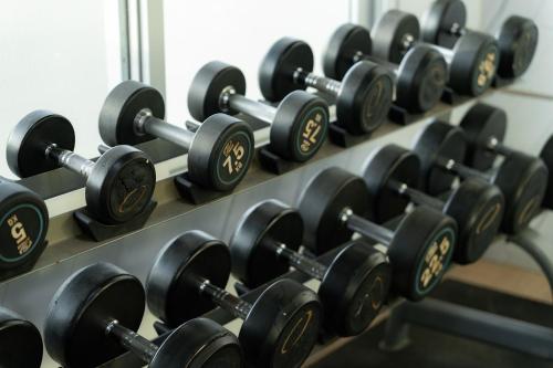 a row of dumbbells on a rack in a gym at TJ 4711 Residence in Maha Sarakham
