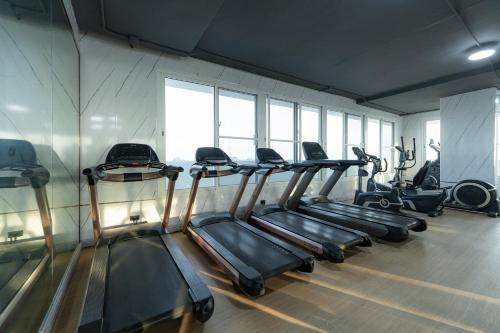 a gym with several tread machines in a row at TJ 4711 Residence in Maha Sarakham