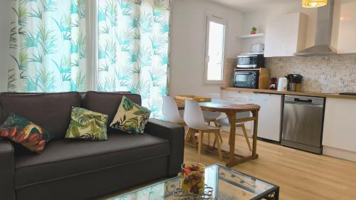 un salon avec un canapé et une table dans l'établissement Guadariege - Proche Hypercentre - 4 personnes, à Troyes