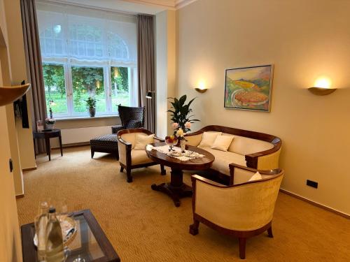 a living room with a couch and a table at Privat-Hotel Villa Aurora in Bad Neuenahr-Ahrweiler