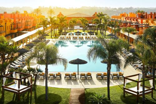 une vue aérienne d'une piscine de complexe hôtelier avec tables et parasols dans l'établissement NH Marina Portimao Resort, à Portimão