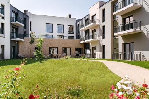 an image of an apartment complex with a yard at Zenitude Hôtel-Résidences Ploërmel in Ploërmel