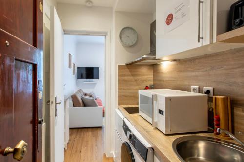 une cuisine avec un évier et un micro-ondes sur un comptoir dans l'établissement C13 - Studio Blvd Carnot 10 min Palais Festivals - Balcony & AC, à Cannes