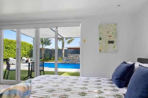 una camera con letto e vista sulla piscina di Amaroo - poolside studio near Pukekura Park a New Plymouth
