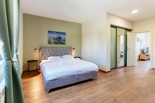 una camera da letto con un grande letto con lenzuola bianche di Villa Dussi a Žabljak