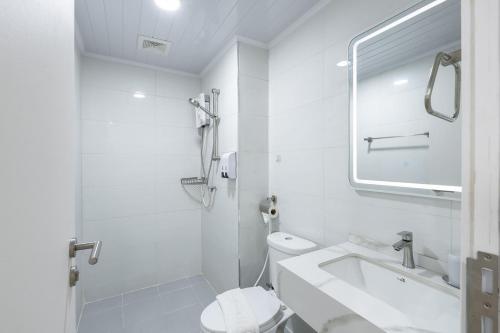 a white bathroom with a toilet and a sink at TJ 4711 Residence in Maha Sarakham