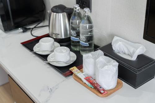 a table with a tray with a bottle of water and a tea set at TJ 4711 Residence in Maha Sarakham