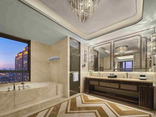 a bathroom with a tub and a large window at Wanda Vista Tianjin in Tianjin
