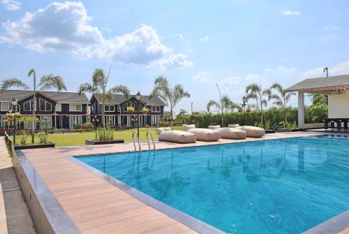a swimming pool in a yard with a house at Luxury 4BHK with Garden Pool and Entertainment Space in Palāhu