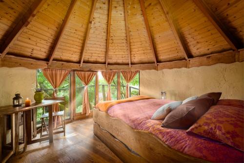 a bedroom with a large bed in a room with wooden ceilings at Agroturismo Mari Cruz in Villanueva de Arce