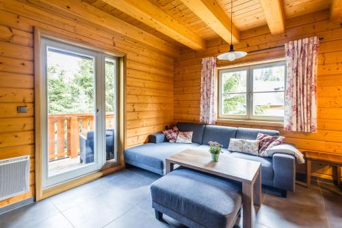 a living room with a couch and a table at Stylová chalupa Ostružná se saunou in Ostružná