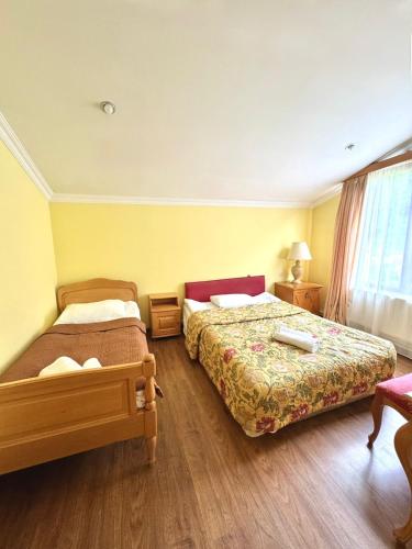 a hotel room with two beds and a window at Hotel Lileo in Mestia