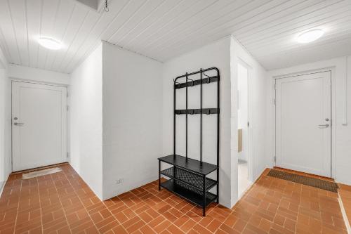 a room with white walls and a black shelf at Lovely Holiday Home, Completely Renovated In 2025, In Quiet And Beautiful Surroundings in Sønder Felding