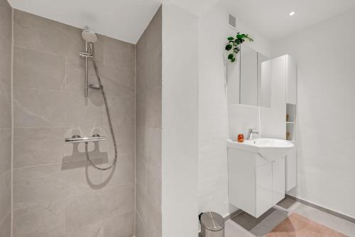 a white bathroom with a shower and a sink at Lovely Holiday Home, Completely Renovated In 2025, In Quiet And Beautiful Surroundings in Sønder Felding