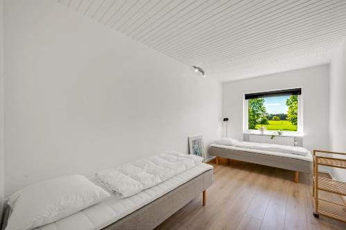 a white room with two beds and a window at Lovely Holiday Home, Completely Renovated In 2025, In Quiet And Beautiful Surroundings in Sønder Felding