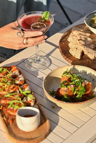 a table with a plate of food and a glass of wine at Hôtel Bor in Hyères
