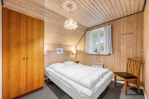 a bedroom with a large bed in a wooden room at Large Holiday Home With Pool, Spa And Sauna, 1500 Meters From The North Sea in Ulfborg