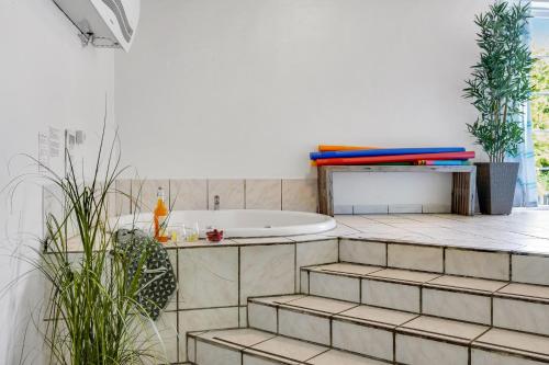 a bathroom with a bath tub and a sink at Large Pool House For 24 People, With Almost Everything In Activities, 300 Meters From The Fjord in Vinderup