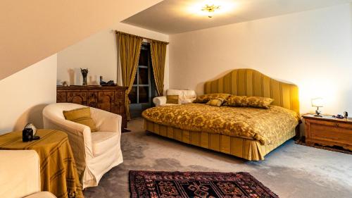 a bedroom with a bed and a chair at Villa Bostele with Five Bedrooms, Indoor Pool, Two Saunas & Garage in Bad Kleinkirchheim