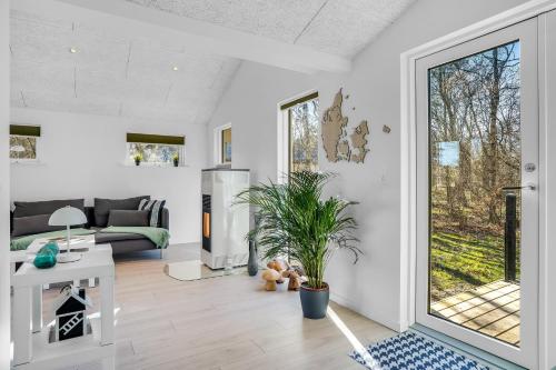 a living room with a couch and a table at Lovely Renovated Holiday Home With A Wilderness Bath And Fenced Grounds in Vesløs