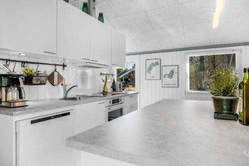 a white kitchen with a large white counter top at Lovely Renovated Holiday Home With A Wilderness Bath And Fenced Grounds in Vesløs
