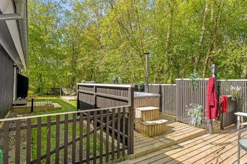 a wooden deck with a table and a fence at Lovely Renovated Holiday Home With A Wilderness Bath And Fenced Grounds in Vesløs