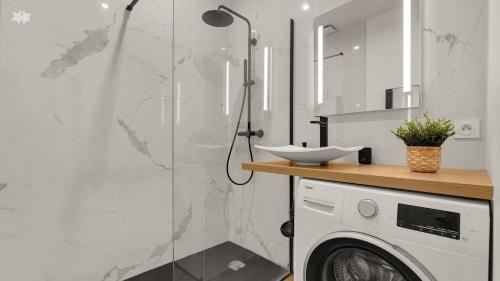 une salle de bain avec douche et machine à laver dans l'établissement Le Floral - Parking privé - Climatisation, à Toulouse