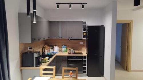 a kitchen with gray cabinets and a black refrigerator at Wind Rose Montenegro in Igalo
